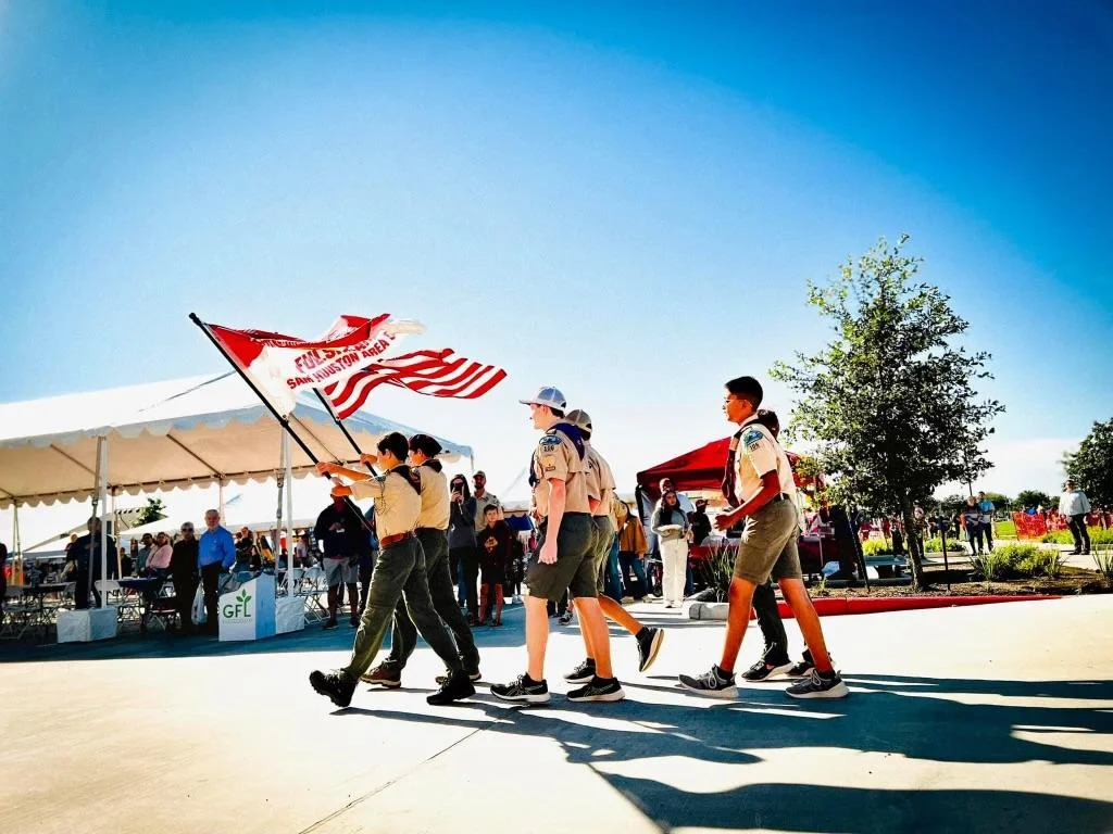 Troop 106 Scouts carrying flags outdoors
